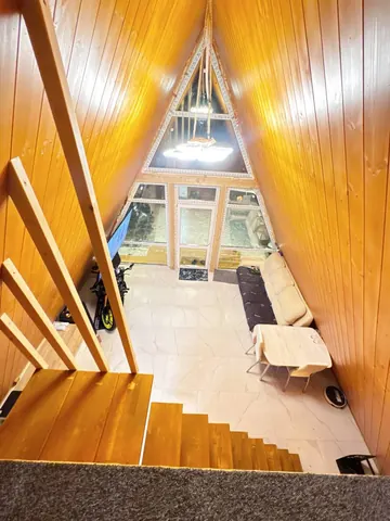 Вид со второго уровня на остеклённый фронтон бани A-Frame