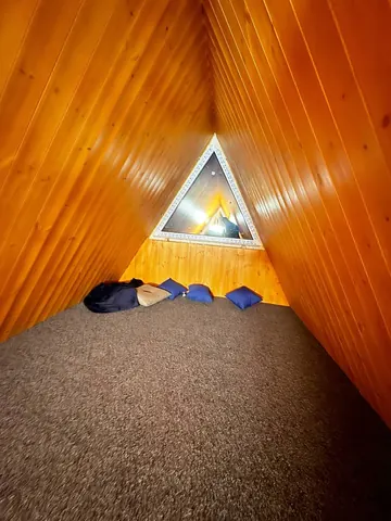 Спальное место под коньком на втором уровне бани A-Frame