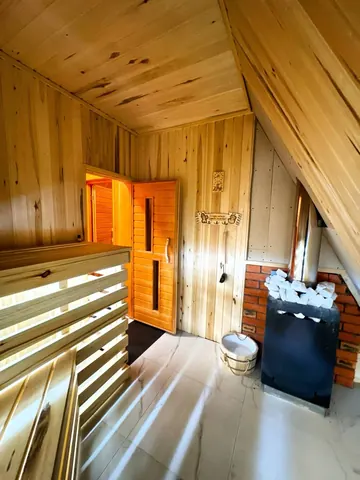 Парная бани A-Frame: полки из дерева и печь с камнями