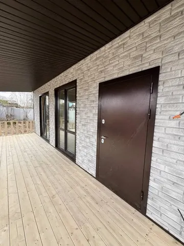 Крытая терраса дома 140 м²: входная дверь и фасад под кирпич