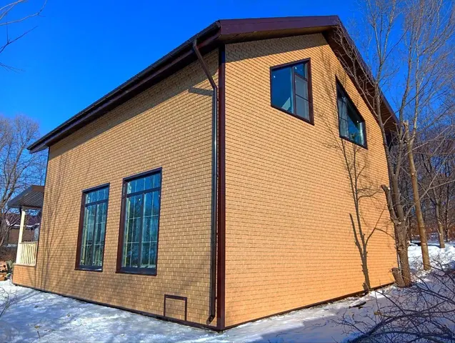 Дом 160 м² с фасадом под кирпич, вид с угла зимой
