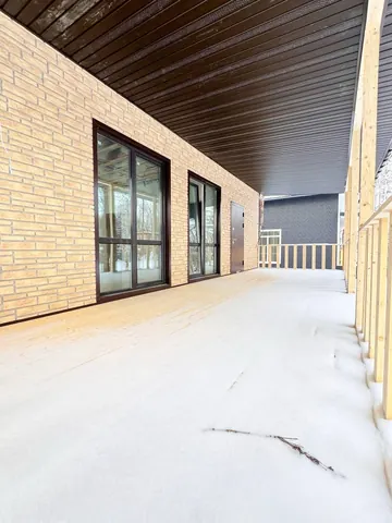 Под навесом террасы: панорамные окна дома 180 м²