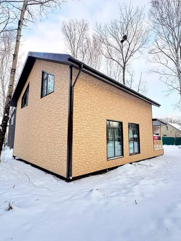 Дом 180 м² со светлым фасадом, вид сзади
