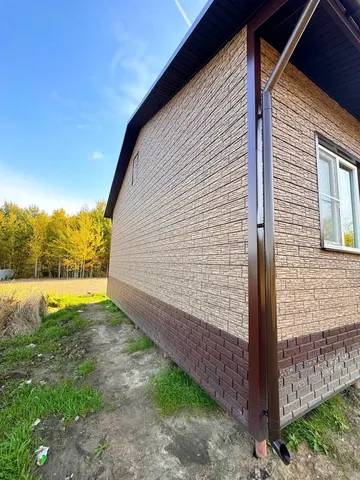 Фасадная панель и водосток на углу дома 99 м²
